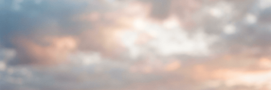 Soft sunset over rolling countryside beneath cloudy skies